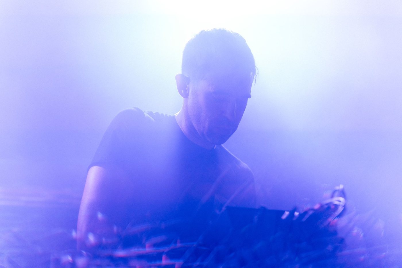 Parts Project at the machines, lit violet through heavy haze
